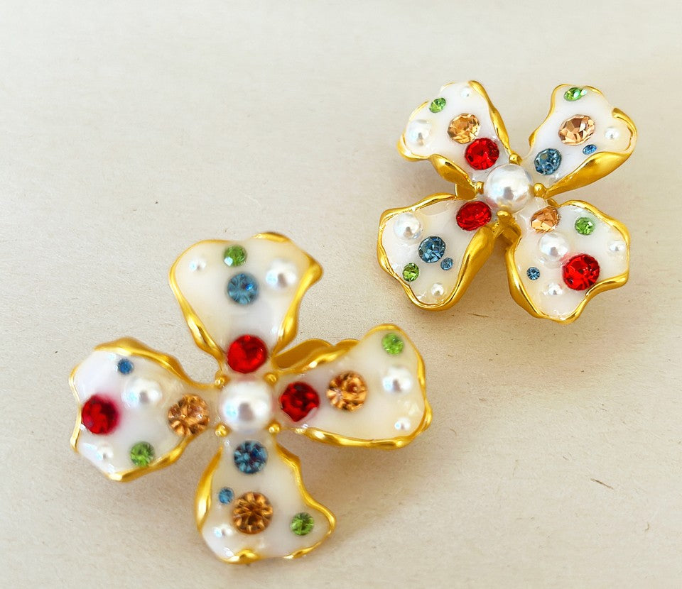 Pretty flower shaped clip on style earrings set in a gold tone metal finish.