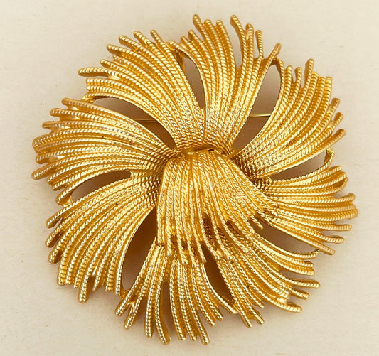 Mid-century style brooch in a gold tone metal finish.