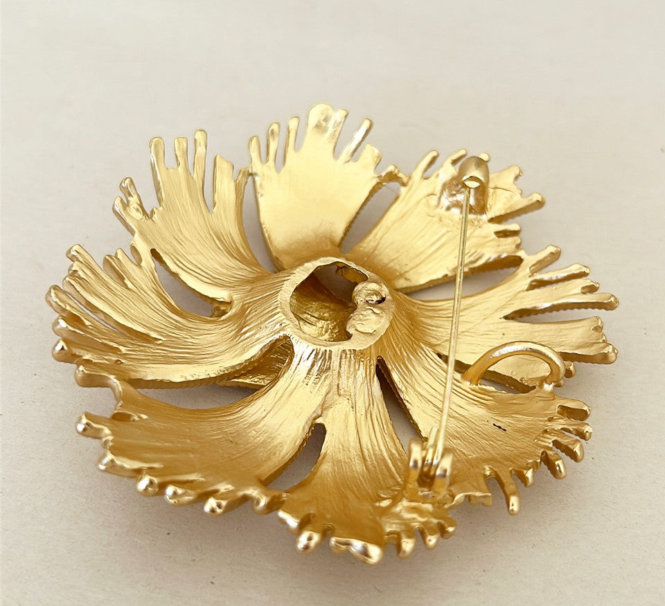 Mid-century style brooch in a gold tone metal finish.